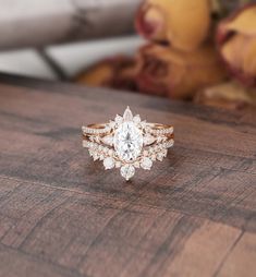 a close up of a ring on a wooden table with a teddy bear in the background