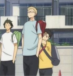 three young men are walking down the street with backpacks on their shoulders and one man is