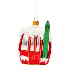 a red bus ornament hanging on a white wall next to a green pole