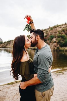 a man and woman kissing on the beach