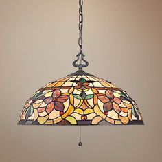 a stained glass light hanging from a chain on a wall with a lamp shade over it