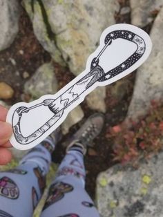 a person holding up a sticker with a drawing on it