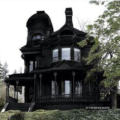 an old black victorian house in the woods