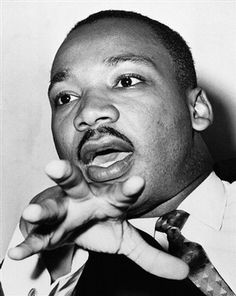 a black and white photo of a man making a face with his finger to the side