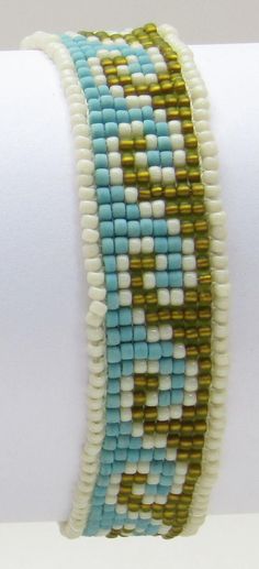 a close up of a bracelet on a person's arm with white and blue beads