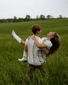 a man carrying a woman in the middle of a field