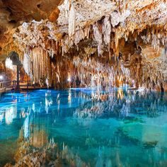 the inside of a cave with blue water