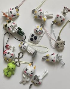 many different key chains with cats and dogs attached to them on a white table top