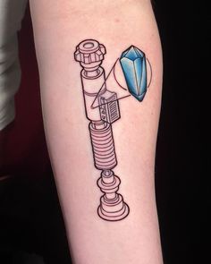 a tattoo on the arm of a woman with a diamond and telescope in it's center