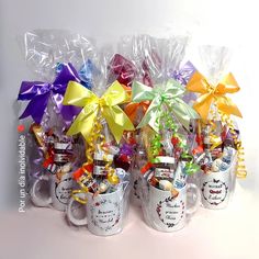 several coffee mugs with colorful bows and candy in them are sitting next to each other