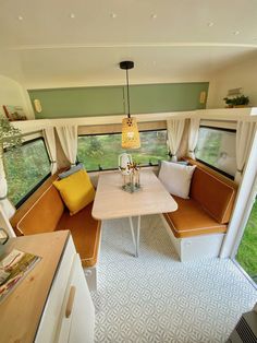 the interior of a camper with two couches and a dining table in it