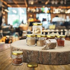 jars filled with spices sitting on top of a wooden table