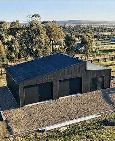 an aerial view of a black house in the country