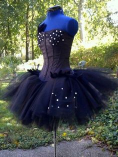 a black and blue dress with white dots on the bust, sitting on a mannequin