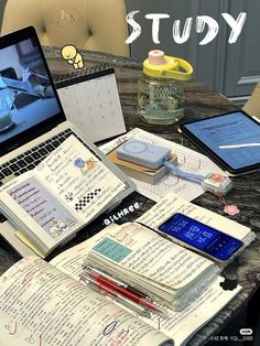 an open laptop computer sitting on top of a table next to books and notebooks