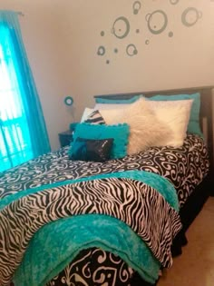 a bedroom with zebra print bedding and blue curtains