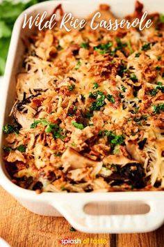 a casserole dish with chicken, cheese and parsley in a white baking dish