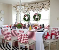 a table with red and white checkered cloths on it, surrounded by christmas decorations