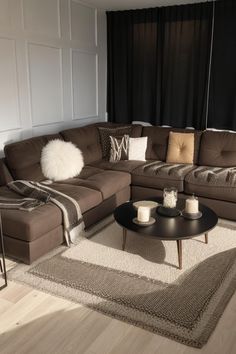 a living room with brown couches and white rugs on the hardwood flooring