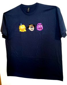 three t - shirts with emojons on them are hanging up against a wall