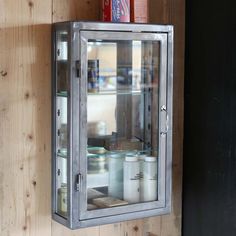 a metal and glass display case on a wooden wall