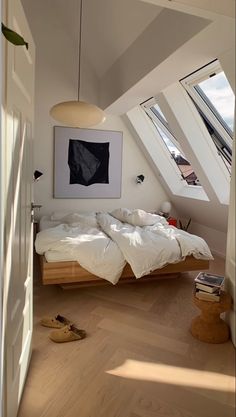 an attic bedroom with white walls and wood flooring