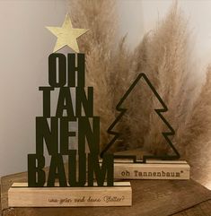 there is a wooden christmas tree on top of two bookends that read oh tan nen baum