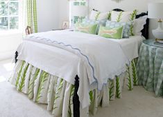 a bedroom with white walls and green bedding