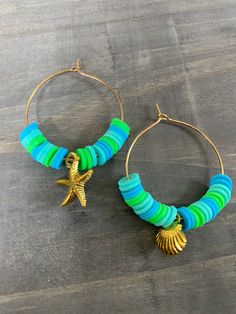 the hoop earrings are decorated with colorful beads and a starfish charm on each side