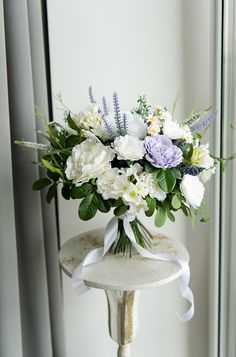 a vase filled with white and purple flowers