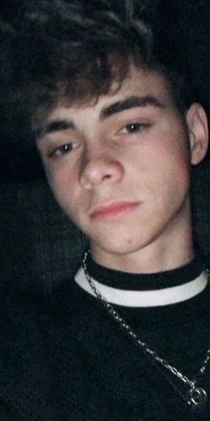 a young man wearing a chain around his neck