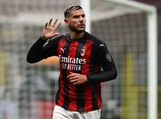 a soccer player with his hand up in the air