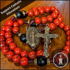 All Proceeds Go Towards Catholic Education! This Handmade Imitation Red Turquoise and Matte Onyx Rosary features an Heirloom Sacred Heart Crucifix paired with a Miraculous Medal Centerpiece, both made from real, authentic bronze and crafted by a local Arizona craftsman. The deep red tones of its turquoise beads complement its black Onyx Our Father beads, gold spacers, and bronze medals to produce a uniquely royal visual appeal, while its ideal knot placement incorporates greater tactile engagement to facilitate a truly sacramental experience. Every knot features five loops designed to evoke meditation upon the five wounds of Christ. All of our rosaries are handcrafted using 100lb tensile strength paracord made in the USA as well as a lifetime warranty if anything breaks! - Fits Perfectly o Adjustable Red Beaded Necklace With 8mm Beads, Red Gemstone Spiritual Beads, Adjustable Red Rosary With 8mm Beads, Handmade Red Rosary For Jewelry Making, Spiritual Red Coral Beads, Adjustable Red Rosary With Round Beads, Red Adjustable Rosary With Round Beads, Adjustable Red Rosary, Red Spiritual Jewelry With Black Beads