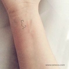 a small tattoo on the wrist of a person with a cat's head drawn on it