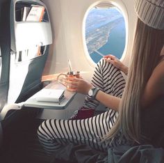 a woman sitting in an airplane looking out the window