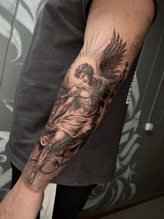 a man's arm with an angel tattoo on it