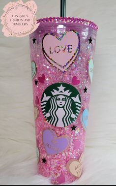 a pink starbucks cup with hearts, stars and glitters on the bottom is shown