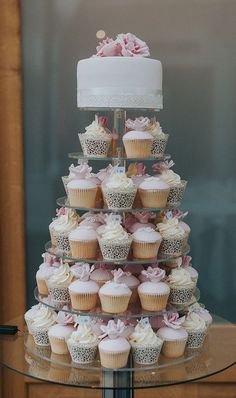 cupcakes are stacked on top of each other in front of a glass table