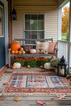 a porch decorated with pumpkins, gourds and flowers