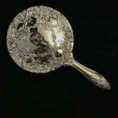 an ornately decorated spoon on a black background