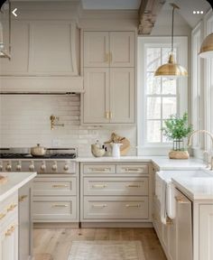 a kitchen with white cabinets and gold hardware on the handles, counter tops and drawers