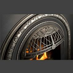 a close up of a fire in a fireplace with ornate designs on the front and sides