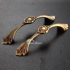 pair of gold plated metal flowers and leaves cufflinks on black leather background