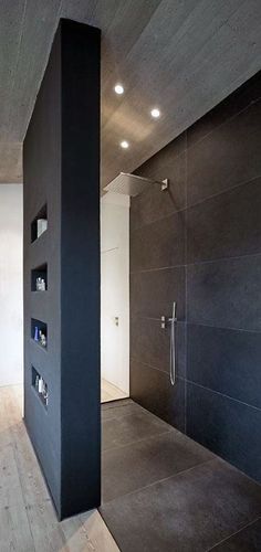 an empty bathroom with black walls and wooden floors