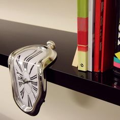 an alarm clock is sitting on a shelf next to some books and binder holders