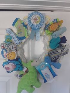 a wreath with baby items hanging on the front door