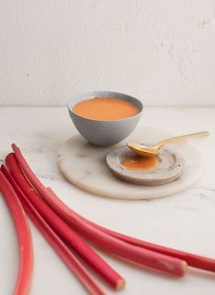 a bowl of soup and some chopsticks on a white plate with a spoon