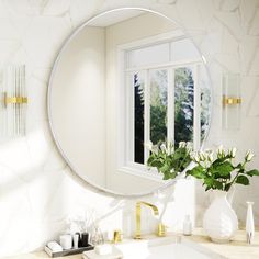 a bathroom sink with a round mirror above it and flowers in vases on the counter