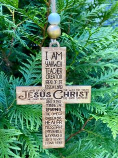 a wooden cross hanging from a tree with the words jesus christ written in different languages