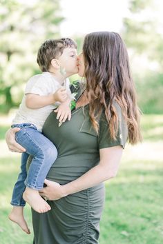 a pregnant woman kissing her son on the cheek